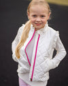 Young girl wearing a white quilted jacket with a pink zipper against a black background